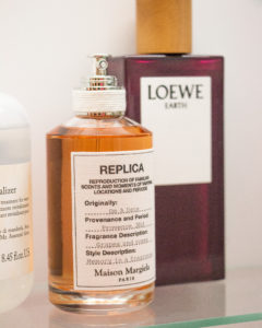 Maison Margiela und Loewe Parfüms auf einem Glasgestell arrangiert.