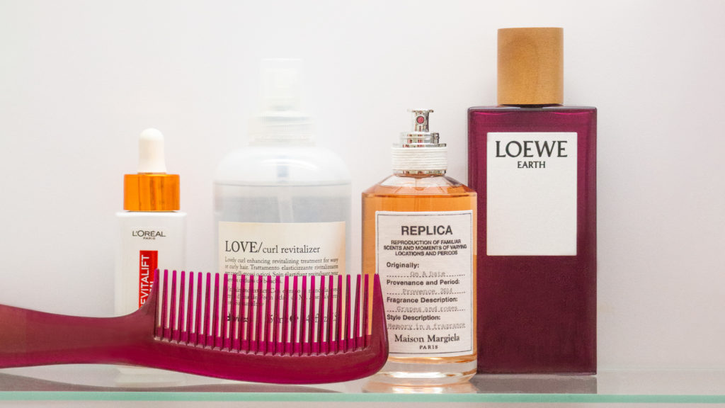 Beauty Produkte auf einem Glasgestell arrangiert. L'Oréal, Davines, Maison Margiela und Loewe.