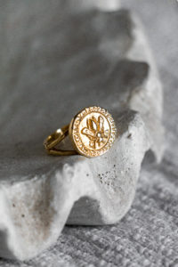 Goldener Ring in einer Muschel arrangiert und mit natürlichem Licht beleuchtet.